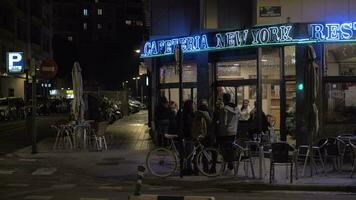 Night street with people saying bye to each other near the cafe, Valencia video