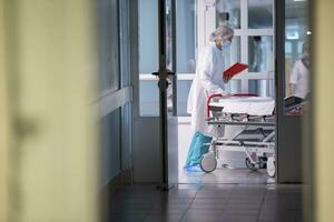 un enfermero empuja un camilla con un camilla en el hospital corredor.hospital corredor. foto
