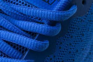 Fragment of a blue sneaker with drawstring macro.Sneaker texture photo