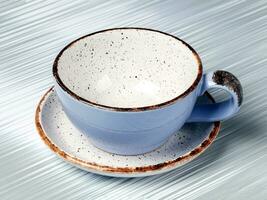 Empty blue ceramic cup on a gray background. photo