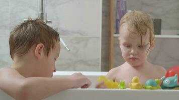 Fratrie prise une une baignoire et en jouant avec jouets video