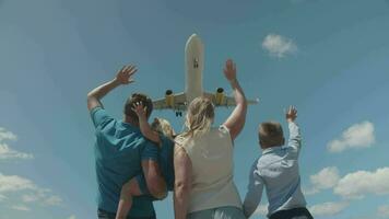 un joven familia saludo un avión, volador encima video