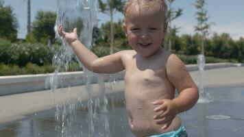 Baby girl having enjoyable summer day and playing with fountain jet video