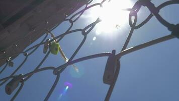 en närbild av en metall maska staket med symbolisk lås på den video