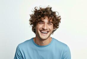 A curly haired man smiling against a white background photo