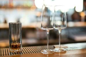 empty clean glass glasses for alcoholic drinks in a restaurant on a bar counter photo