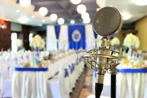 Musical Retro microphone in a festive hall. Speaking equipment on the stage, preparation for the performance, event, wedding. Horizontal photography for poster, flyer, adwertisement. photo