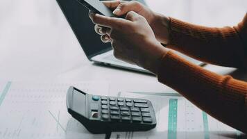 Asian Businesswoman Using laptop computer and working at office with calculator document on desk, doing planning analyzing the financial report, business plan investment, finance analysis concept. video