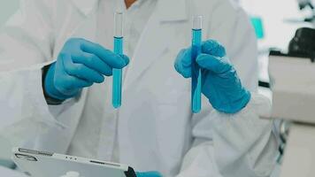 Health care researchers working in life science laboratory. Young female research scientist and senior male supervisor preparing and analyzing microscope slides in research lab. video