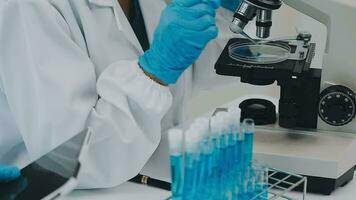 Health care researchers working in life science laboratory. Young female research scientist and senior male supervisor preparing and analyzing microscope slides in research lab. video