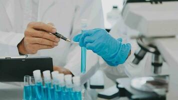 Health care researchers working in life science laboratory. Young female research scientist and senior male supervisor preparing and analyzing microscope slides in research lab. video