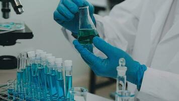 Health care researchers working in life science laboratory. Young female research scientist and senior male supervisor preparing and analyzing microscope slides in research lab. video