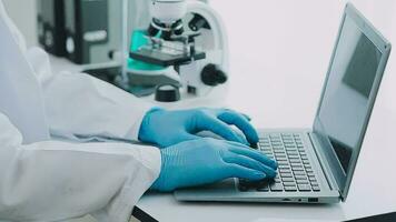 Health care researchers working in life science laboratory. Young female research scientist and senior male supervisor preparing and analyzing microscope slides in research lab. video