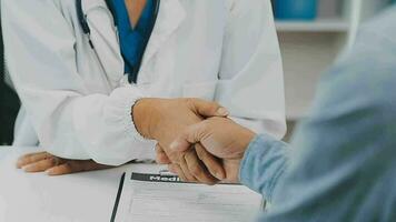 Doctor and patient sitting and talking at medical examination at hospital office, close-up. Therapist filling up medication history records. Medicine and healthcare concept. video