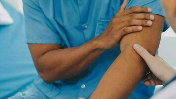 Doctor and patient sitting and talking at medical examination at hospital office, close-up. Therapist filling up medication history records. Medicine and healthcare concept. video