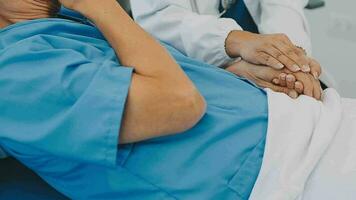 Doctor and patient sitting and talking at medical examination at hospital office, close-up. Therapist filling up medication history records. Medicine and healthcare concept. video