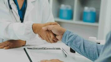 Doctor and patient sitting and talking at medical examination at hospital office, close-up. Therapist filling up medication history records. Medicine and healthcare concept. video