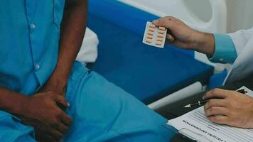 Doctor and patient sitting and talking at medical examination at hospital office, close-up. Therapist filling up medication history records. Medicine and healthcare concept. video