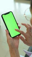 hand- Holding mobiel telefoon met groen scherm Bij huis, gebruik makend van telefoon groen scherm, groen scherm, smartphone groen scherm video