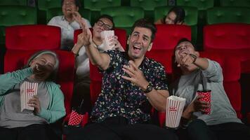 groupe de asiatique Sénior copains en train de regarder comédie film et rire à le cinéma avec pop corn video