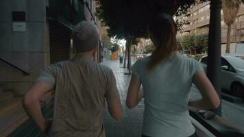 A back view of a couple jogging along the paved sidewalk video