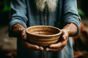 Selective focus on impoverished old mans hands clutching an empty bowl AI Generated photo