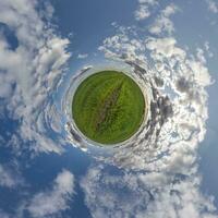 pequeño planeta verde en el cielo azul con hermosas nubes con transformación de panorama esférico de 360 grados. curvatura del espacio. foto