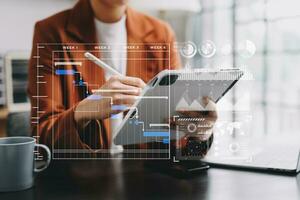 Businessman hand Project manager working and update tasks and Gantt chart scheduling virtual diagram.with smart phone, tablet and laptop in modern office. photo