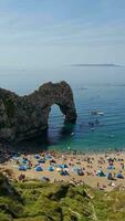 Most Beautiful High Angle View of British Landscape and Sea View of Durdle Door Beach of England Great Britain, UK. Image Was captured with Drone's camera on September 9th, 2023 video