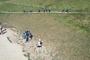 High Angle View of People are Approaching to Durdle Door Beach Which is Most Famous Tourist Attraction Place Through Walking Distance over Landscape and Hills. Captured on September 9th, 2023 photo