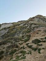 High Angle View of People are Approaching to Durdle Door Beach Which is Most Famous Tourist Attraction Place Through Walking Distance over Landscape and Hills. Captured on September 9th, 2023 photo