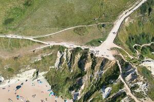 High Angle View of People are Approaching to Durdle Door Beach Which is Most Famous Tourist Attraction Place Through Walking Distance over Landscape and Hills. Captured on September 9th, 2023 photo