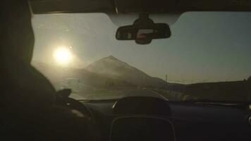 A misty volcano view through the windshield of a driving car video