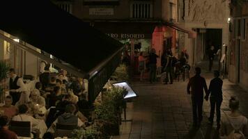 animado calle con al aire libre café en noche Venecia, Italia video