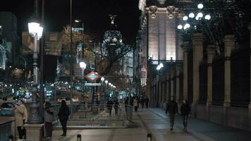 Night view of lively Alcala street with subway station entrance, Madrid video