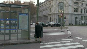 mayor mujer caminando a autobús detener a plaza Delaware cibeles en Madrid, España video