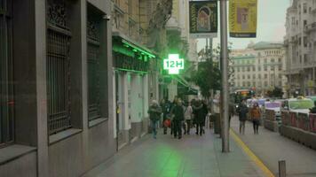 calle con caminando personas y farmacia firmar en Madrid, España video