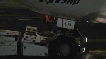 Pushback of Utair airplane at night. View with cockpit and pilot in the cabin video
