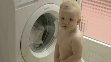 encantador bebé niña es curioso acerca de Lavado máquina video