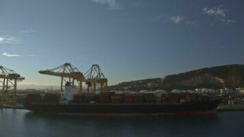 Zeitraffer von Kräne Wird geladen Ladung Schiff mit Behälter beim industriell Hafen, Spanien video