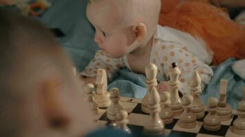 baby meisje is nieuwsgierig over schaak video