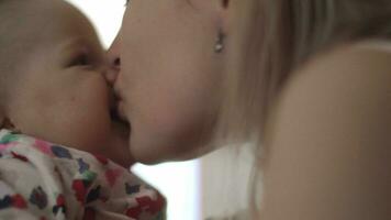 Baby being held and kissed by her mother video