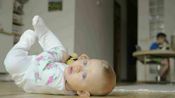 ein Baby Mädchen im ein Strampler passen Lügen auf das Fußboden video