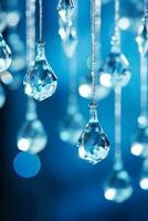 Sparkling glass icicle ornaments catching the ambient light hung delicely isolated on cool-toned winter-blue gradient background photo