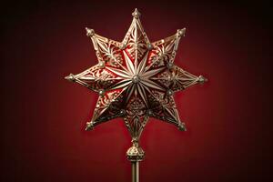 Victorian style Christmas tree topper a golden star gleaming with sparkle isolated on a holiday red gradient background photo