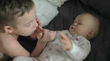 Happy young boy with his baby sister caucasian video