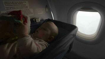 Baby Mädchen im ein Stubenwagen auf ein Flugzeug video