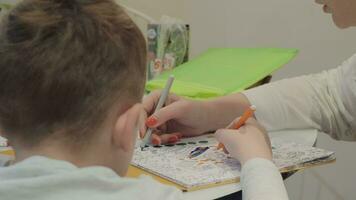 A boy and his mother coloring a picture video