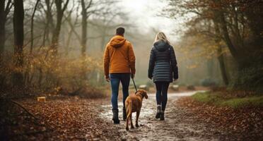 un Pareja y perro caminando en el bosque foto