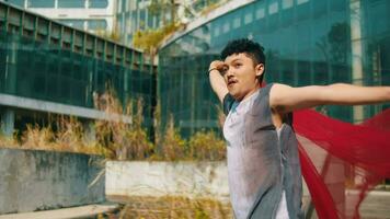 an Asian man runs with a red cloth and waves it behind him very cheerfully when the wind is blowing video